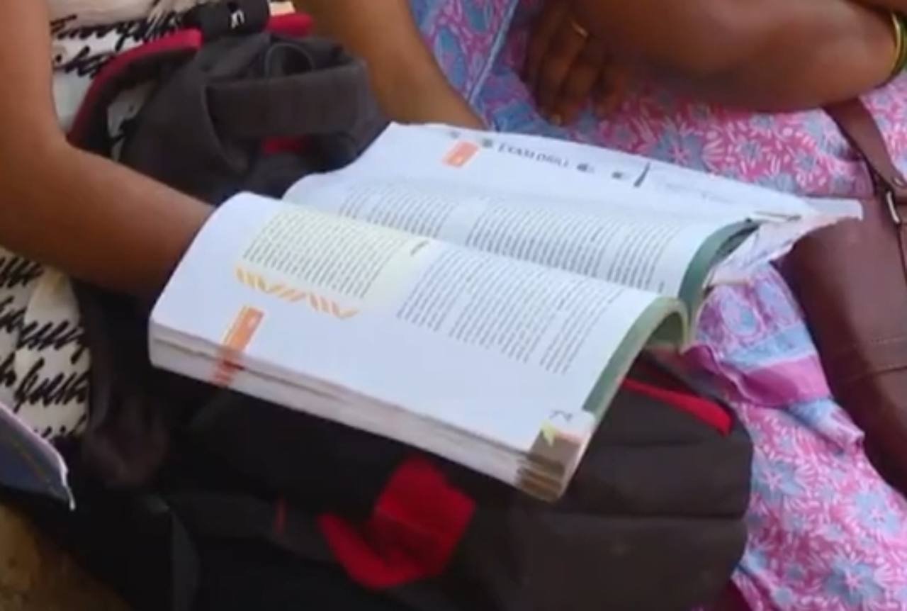 ತೆರೆದ ಪಠ್ಯಪುಸ್ತಕ ಓದುತ್ತಿರುವ ವ್ಯಕ್ತಿ.