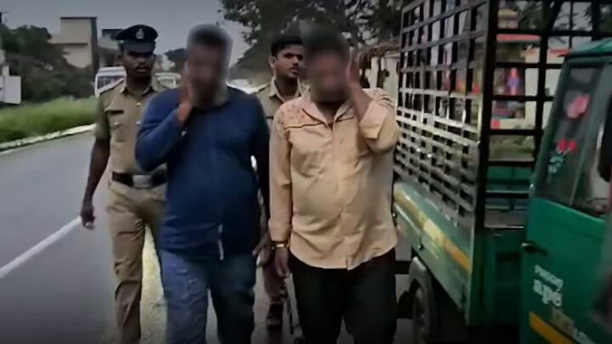 ಮುಖ ಮರೆಮಾಚಿರುವ ಇಬ್ಬರು ದರೋಡೆ ಆರೋಪಿಗಳನ್ನು ಕರೆದೊಯ್ಯುತ್ತಿರುವ ರಾಮನಗರ ಪೊಲೀಸರು